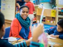 Teaching student in classroom working with children